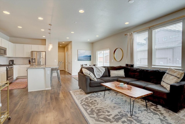 6612 N Ceylon St, Denver, CO 80249 - living area featuring light wood finished floors, recessed lighting, and baseboards