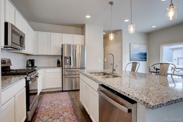 6612 N Ceylon St, Denver, CO 80249 - kitchen featuring stainless steel appliances, a sink, dark wood-type flooring, white cabinets, and recessed lighting