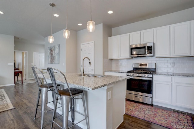 6612 N Ceylon St, Denver, CO 80249 - kitchen featuring appliances with stainless steel finishes, a sink, dark wood finished floors, light stone countertops, and tasteful backsplash