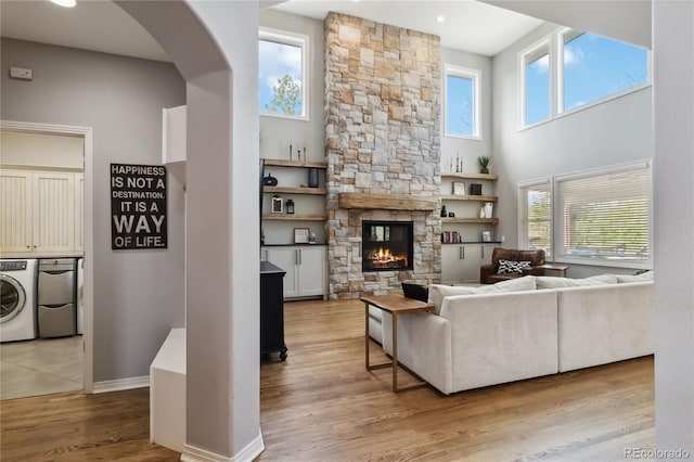living area with plenty of natural light, a fireplace, wood finished floors, and baseboards
