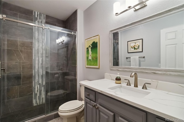 full bath featuring toilet, a shower stall, and vanity