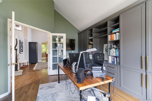 home office featuring high vaulted ceiling, light wood-style flooring, and french doors