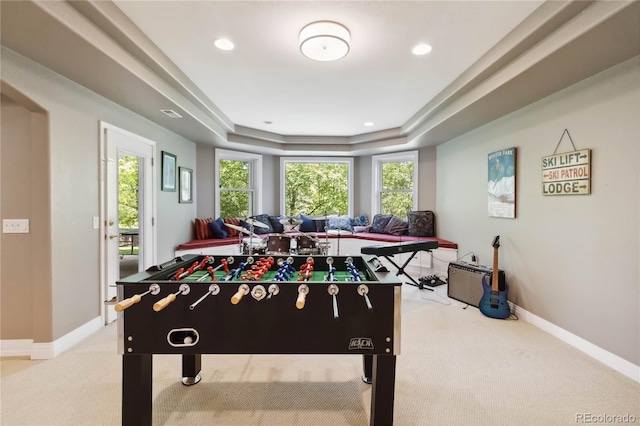rec room featuring light colored carpet, a tray ceiling, baseboards, and recessed lighting