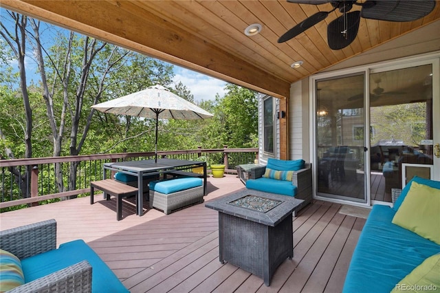 deck featuring a fire pit, ceiling fan, and outdoor dining space