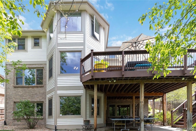 rear view of property featuring stairs and a wooden deck