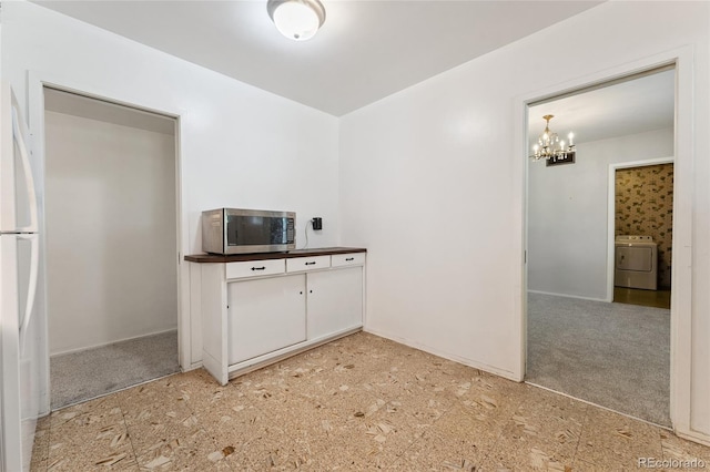 708 Revere St, Aurora, CO 80011 - kitchen featuring stainless steel microwave, washer / dryer, a chandelier, and freestanding refrigerator