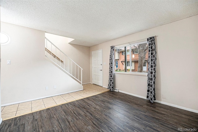 12662 W Virginia Ave, Lakewood, CO 80228 - interior space featuring stairs, a textured ceiling, baseboards, and wood finished floors