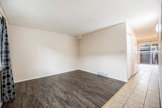 12662 W Virginia Ave, Lakewood, CO 80228 - unfurnished room featuring a textured ceiling, visible vents, wood finished floors, and baseboards