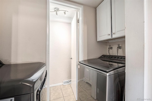 12662 W Virginia Ave, Lakewood, CO 80228 - laundry area with cabinet space, light tile patterned floors, separate washer and dryer, and baseboards