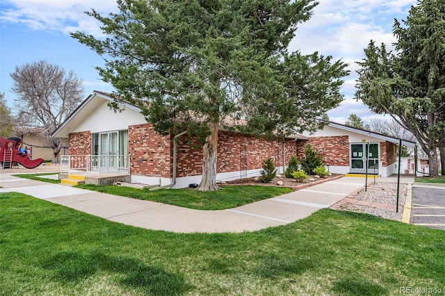 12662 W Virginia Ave, Lakewood, CO 80228 - ranch-style house with brick siding, a front lawn, and a playground