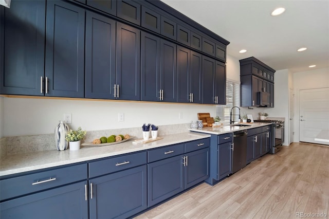 kitchen with recessed lighting, blue cabinets, stainless steel appliances, a sink, and light wood-style floors