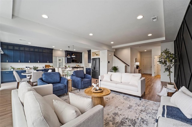 living area featuring light wood-style floors, visible vents, and recessed lighting