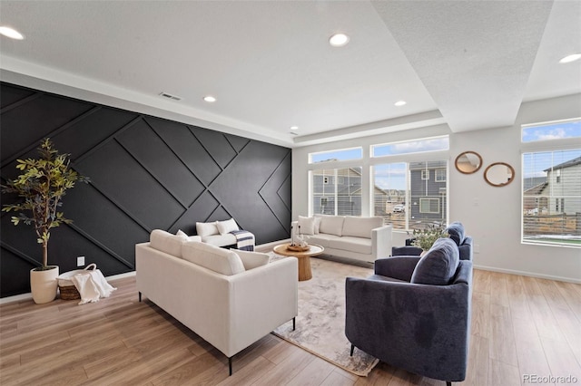 living area with recessed lighting, visible vents, light wood-style flooring, and baseboards