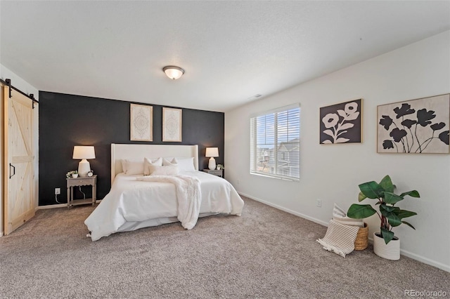 bedroom featuring carpet, a barn door, and baseboards