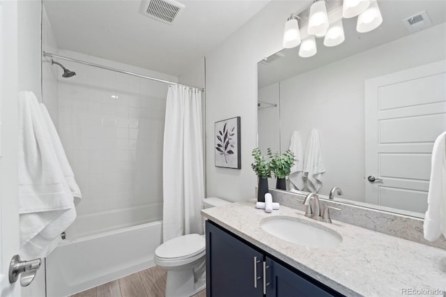 bathroom with toilet, visible vents, wood finished floors, and vanity