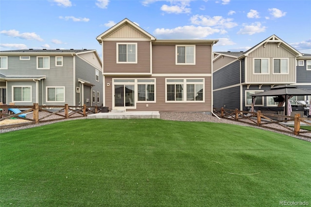 rear view of house featuring a fenced backyard, a patio, a lawn, and a gazebo