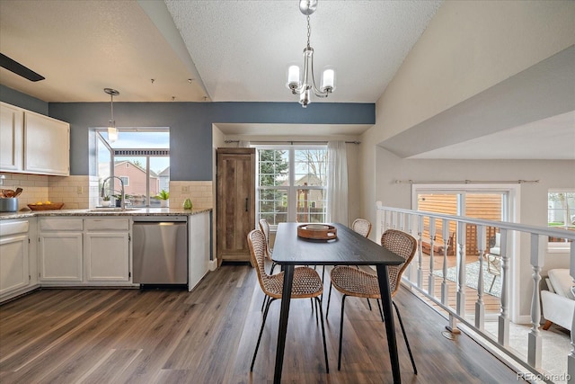 kitchen featuring backsplash, dark wood-style flooring, dishwasher, a sink, and white cabinetry