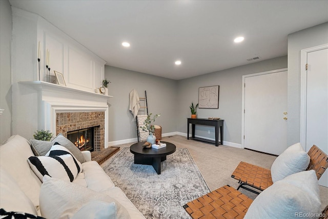 living area with light carpet, a glass covered fireplace, recessed lighting, baseboards, and visible vents
