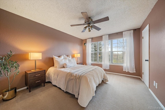 bedroom with a ceiling fan, a textured ceiling, baseboards, and carpet