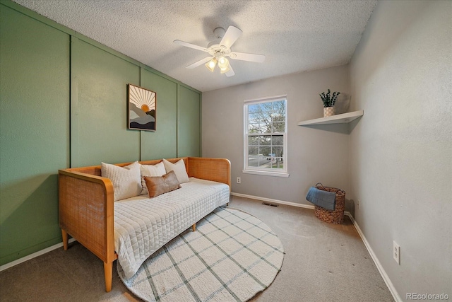 bedroom featuring visible vents, baseboards, ceiling fan, light colored carpet, and a textured ceiling