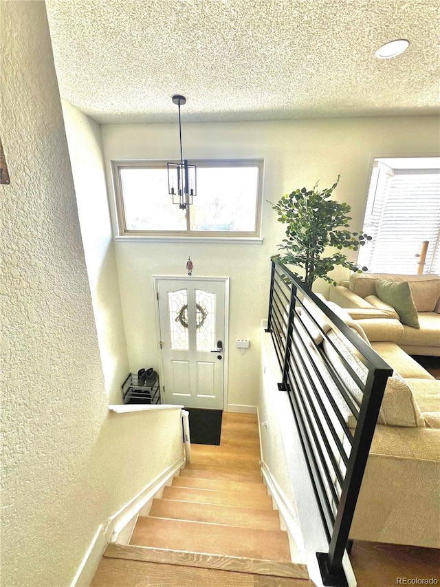 1528 Coronado Pkwy, Denver, CO 80229 - stairway featuring a chandelier, wood finished floors, a textured wall, a textured ceiling, and recessed lighting