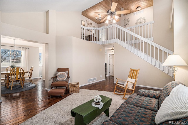 living room featuring ceiling fan with notable chandelier, hardwood / wood-style flooring, stairs, and visible vents