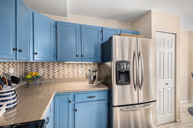 kitchen featuring blue cabinets, range, decorative backsplash, and stainless steel fridge with ice dispenser