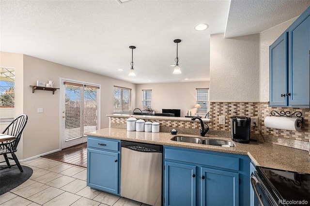 kitchen featuring blue cabinets, a peninsula, a sink, dishwasher, and tasteful backsplash