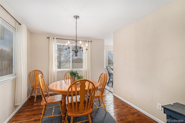 dining room featuring dark wood-style floors, an inviting chandelier, and baseboards