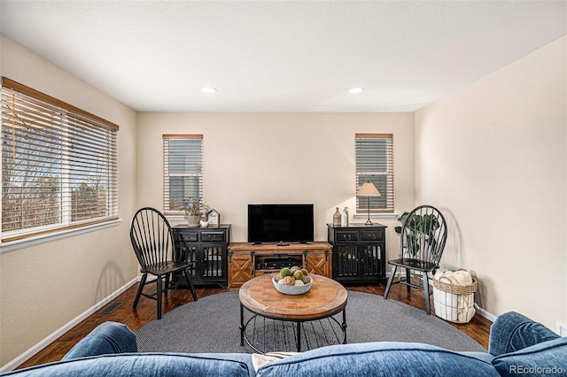 living room with recessed lighting, visible vents, baseboards, and wood finished floors