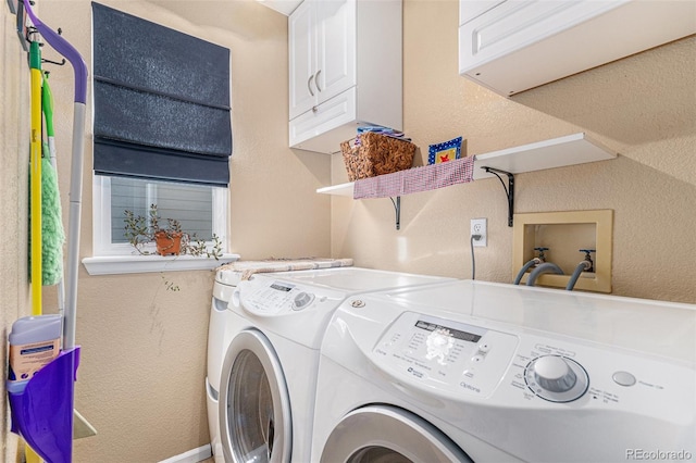 washroom with cabinet space, a textured wall, and washing machine and clothes dryer