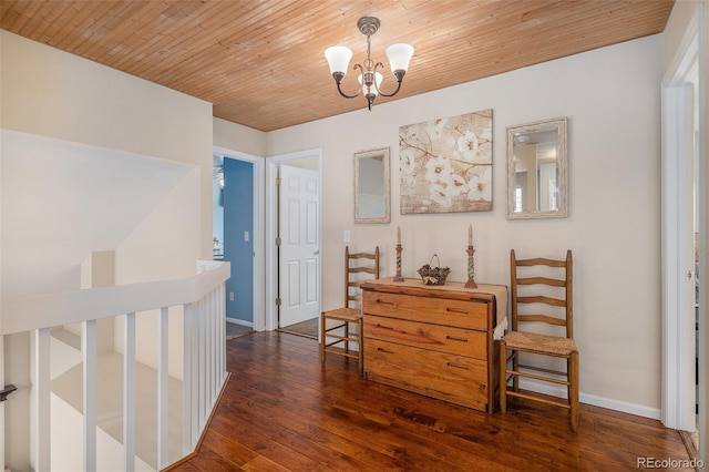 hall with wood ceiling, a chandelier, hardwood / wood-style flooring, and baseboards