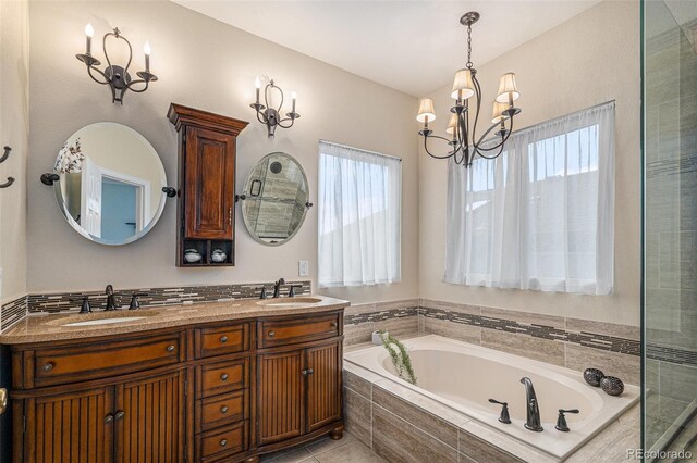 bathroom with a chandelier, double vanity, a sink, and a bath