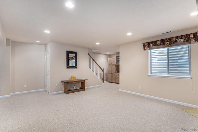 basement featuring baseboards, visible vents, stairs, carpet floors, and recessed lighting