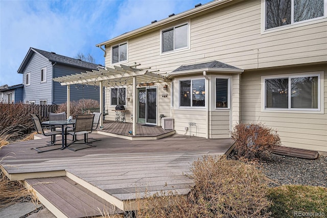 rear view of property featuring outdoor dining space, fence, a deck, and a pergola