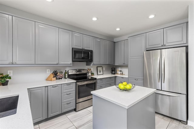 5733 S Yakima Way, Aurora, CO 80015 - kitchen with stainless steel appliances, gray cabinetry, recessed lighting, a center island, and light stone counters