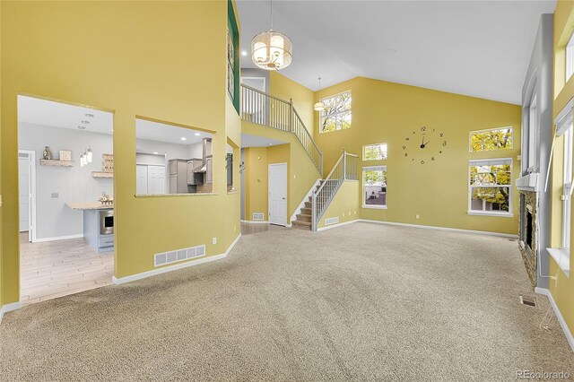 20532 E Lake Cir, Centennial, CO 80016 - unfurnished living room with carpet, high vaulted ceiling, stairway, baseboards, and a fireplace