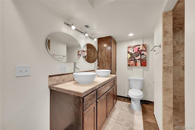 20532 E Lake Cir, Centennial, CO 80016 - bathroom with double vanity, toilet, tile patterned flooring, a tile shower, and recessed lighting