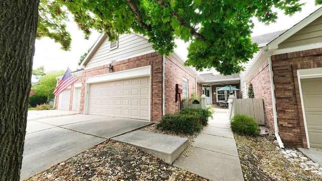 view of side of property with a garage, driveway, and brick siding