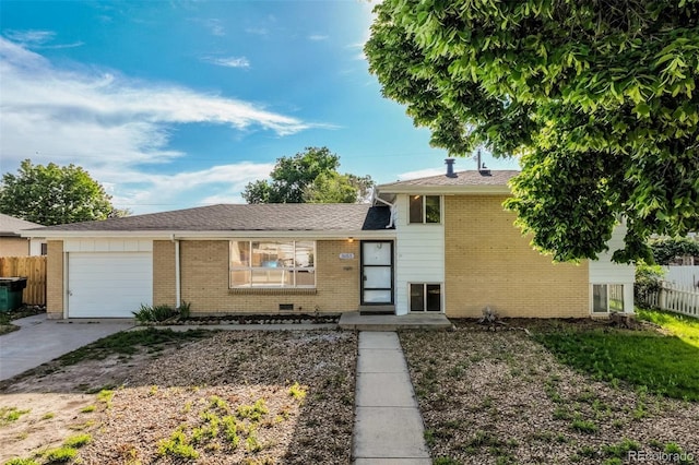 3055 Carson St, Aurora, CO 80011 - split level home with an attached garage, driveway, and brick siding