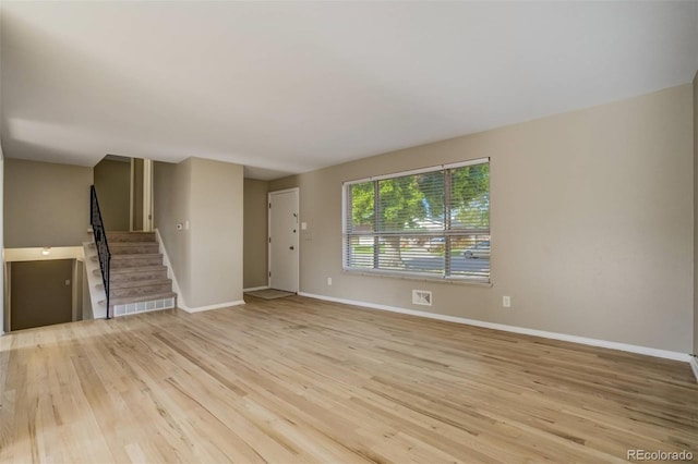 3055 Carson St, Aurora, CO 80011 - unfurnished living room with stairs, light wood-type flooring, and baseboards
