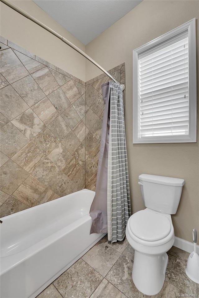 bathroom featuring shower / bath combination with curtain and toilet