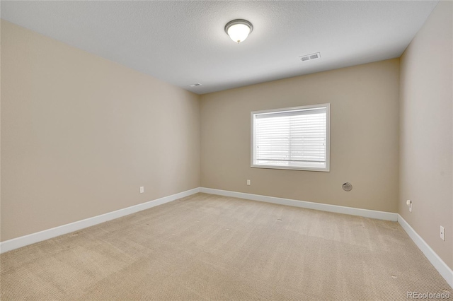 carpeted spare room featuring a textured ceiling