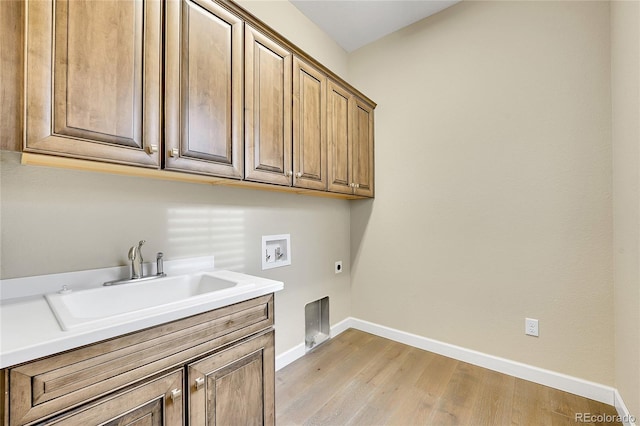 laundry room with sink, cabinets, washer hookup, light hardwood / wood-style floors, and hookup for an electric dryer