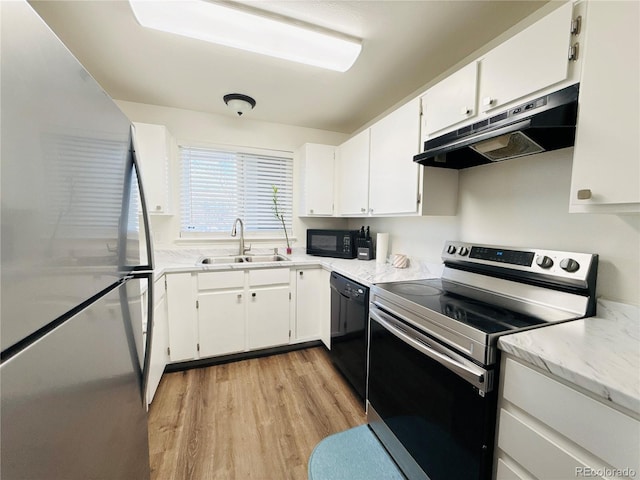 kitchen featuring light wood-style floors, white cabinetry, a sink, under cabinet range hood, and black appliances