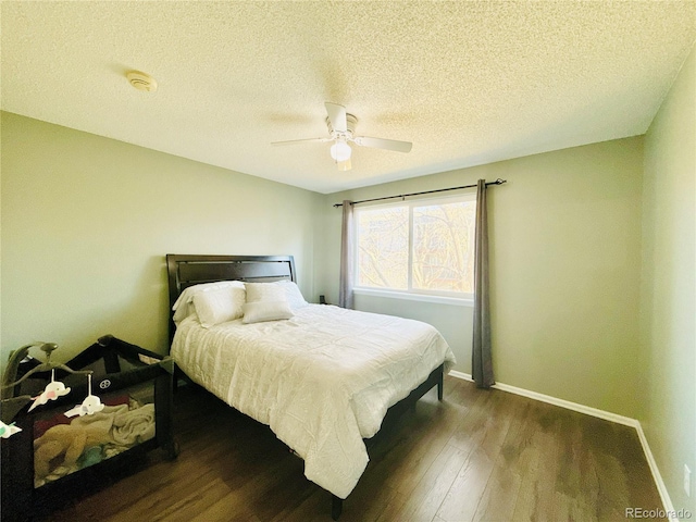 bedroom with ceiling fan, baseboards, a textured ceiling, and wood finished floors