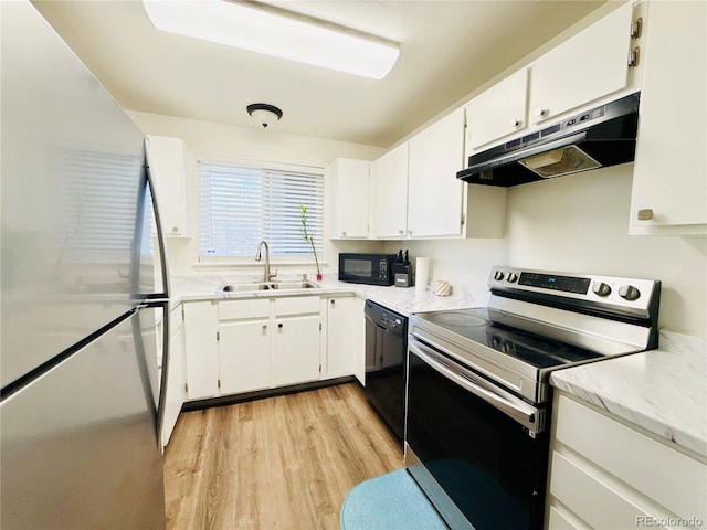 kitchen with white cabinetry, black appliances, under cabinet range hood, a sink, and light wood finished floors