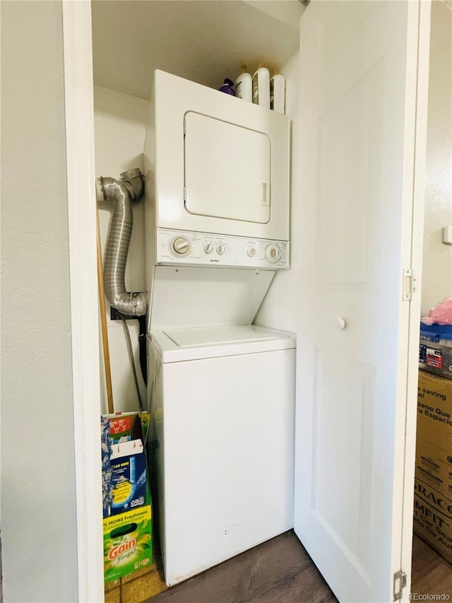 clothes washing area with stacked washing maching and dryer and laundry area