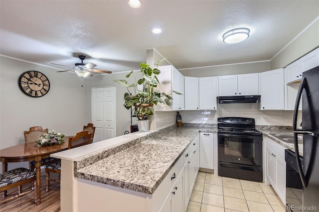 2280 S Oswego Way Unit 104, Aurora, CO 80014 - kitchen with black appliances, under cabinet range hood, a peninsula, white cabinetry, and a textured ceiling