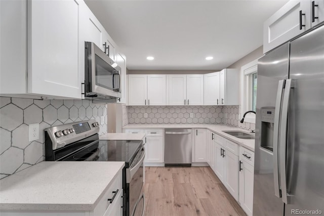 8280 Auburn Ln, Westminster, CO 80031 - kitchen with stainless steel appliances, light wood-style flooring, white cabinetry, recessed lighting, and tasteful backsplash